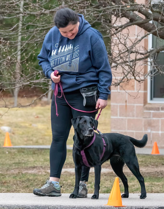 Emily training her black Labrador outdoors